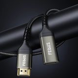 Braided USB to USB-C cable with metallic HDMI male to female cable on a dark background.